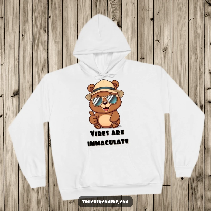 Funny brown bear wearing a trucker hat and aviator sunglasses, giving a thumbs-up, printed on a warm hoodie for cool comfort.